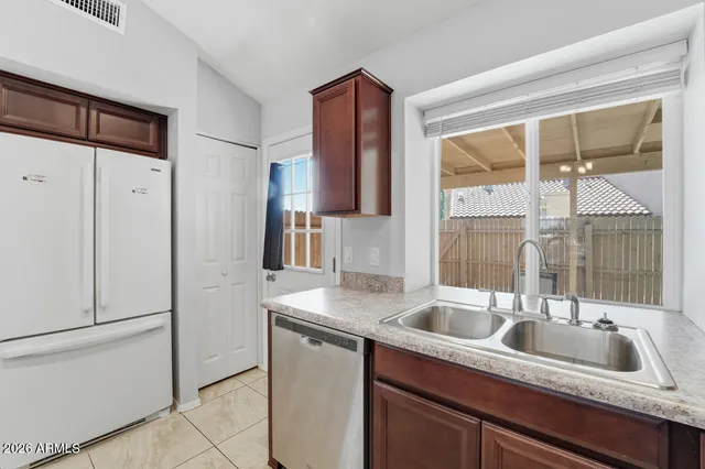 an empty room with chandelier fan and windows