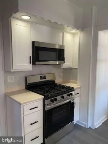 a kitchen with granite countertop a stove and a microwave