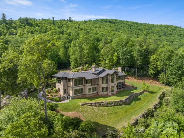 a view of a house with a big yard and large trees