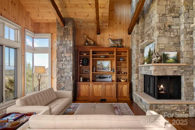 a living room with furniture a fireplace and a floor to ceiling window
