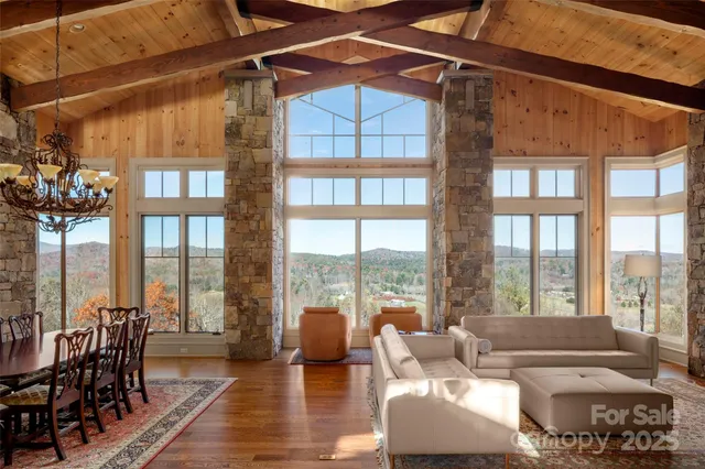 a living room with furniture and floor to ceiling windows