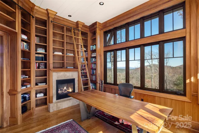 a living room with furniture a fireplace and a floor to ceiling window