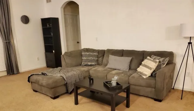 a living room with furniture and a mirror