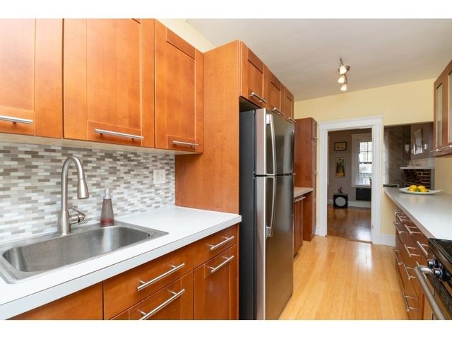 a kitchen with stainless steel appliances a refrigerator sink and cabinets