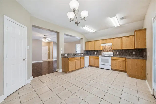 a kitchen with a refrigerator a sink dishwasher with a dining table and chairs
