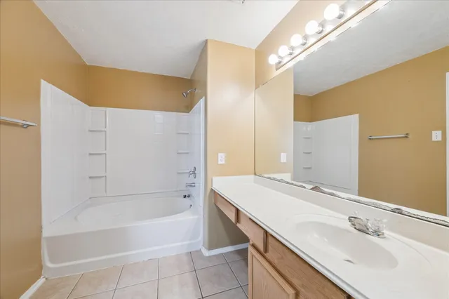 a bathroom with a tub sink and mirror