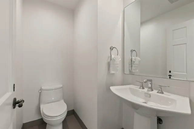a bathroom with a sink toilet and a mirror