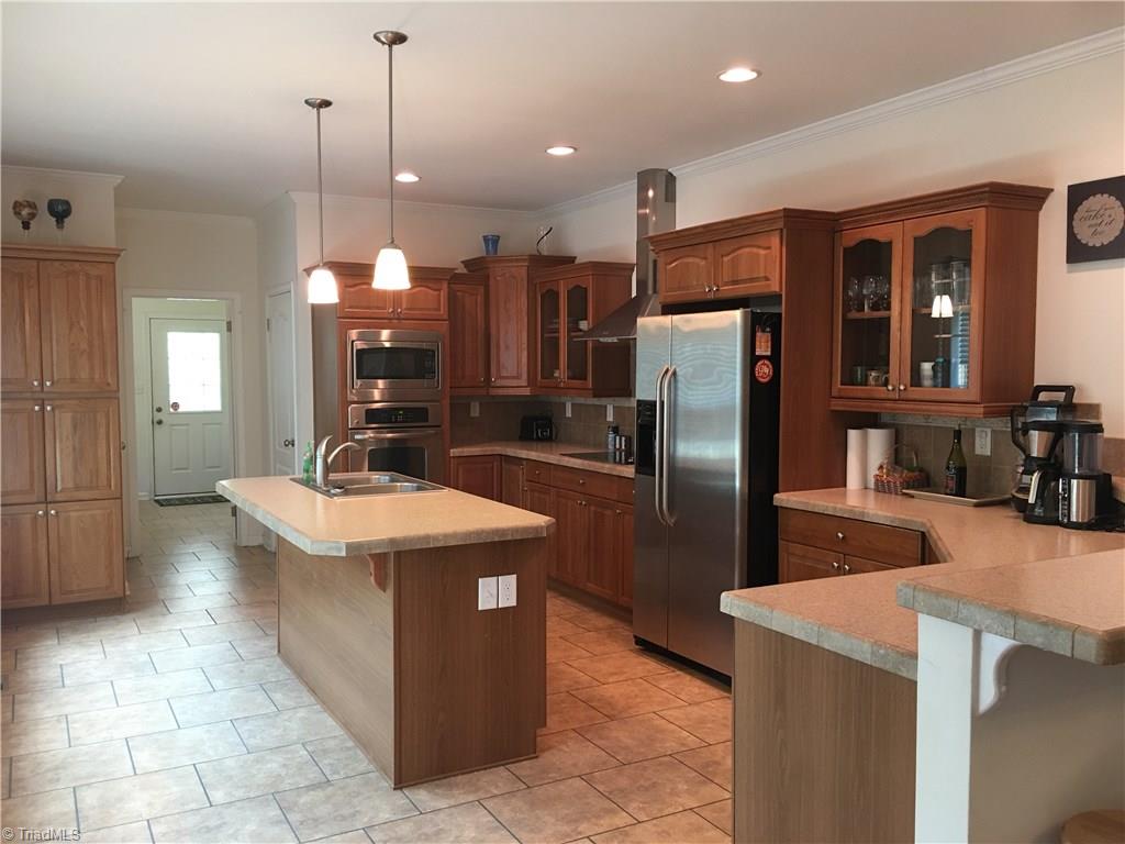 2089 Griffin Road Rural Hall, NC 27045 - Photo 3 of 30 Beautiful open kitchen has two bars with plenty of space to sit 6-7 people. Plus a dining room for more. Notice the Large pantry to the left in the photo.