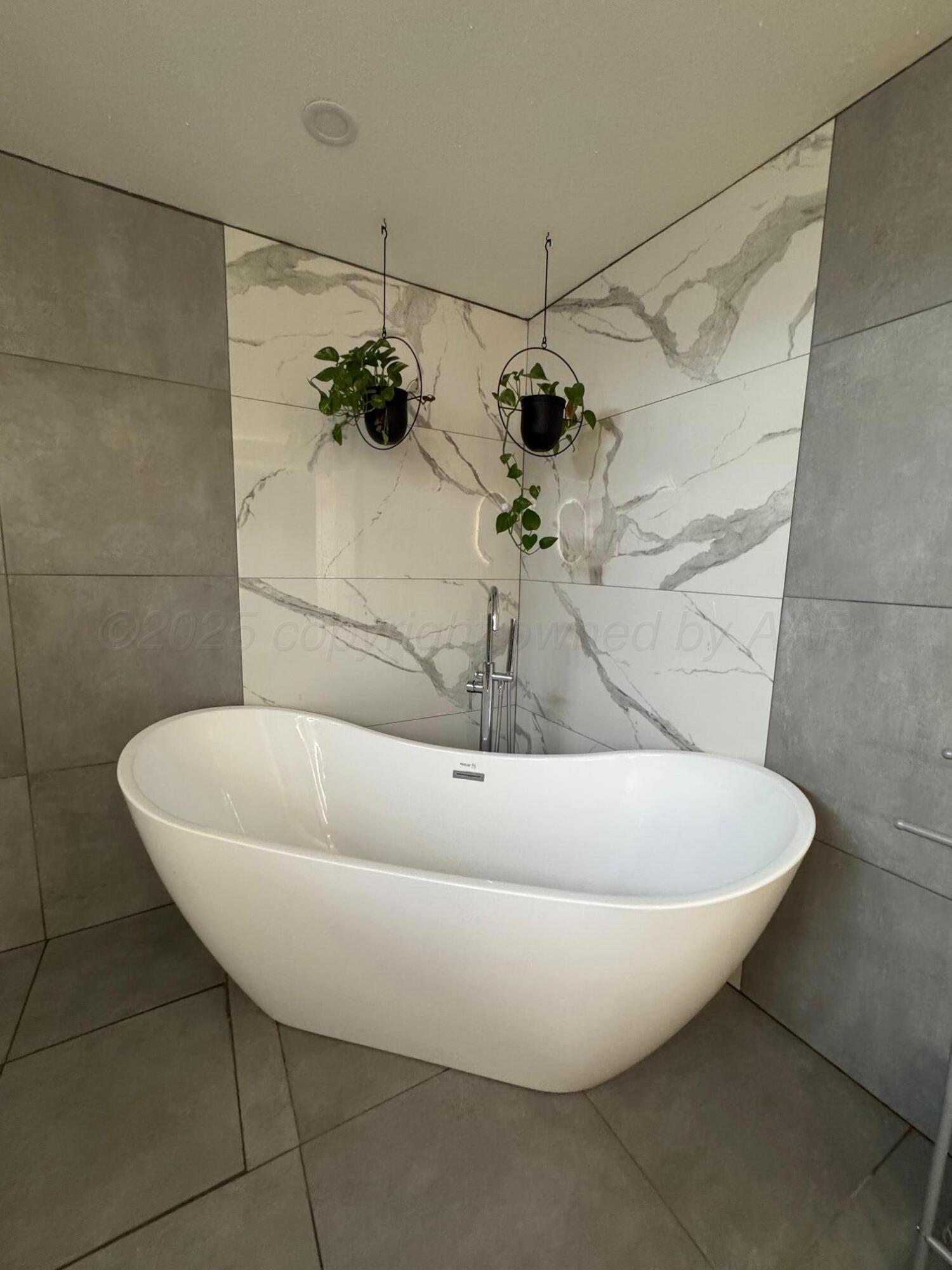 513 South Eton Street Perryton, TX 79070 - Photo 43 of 72 a white bath tub sitting in a bathroom