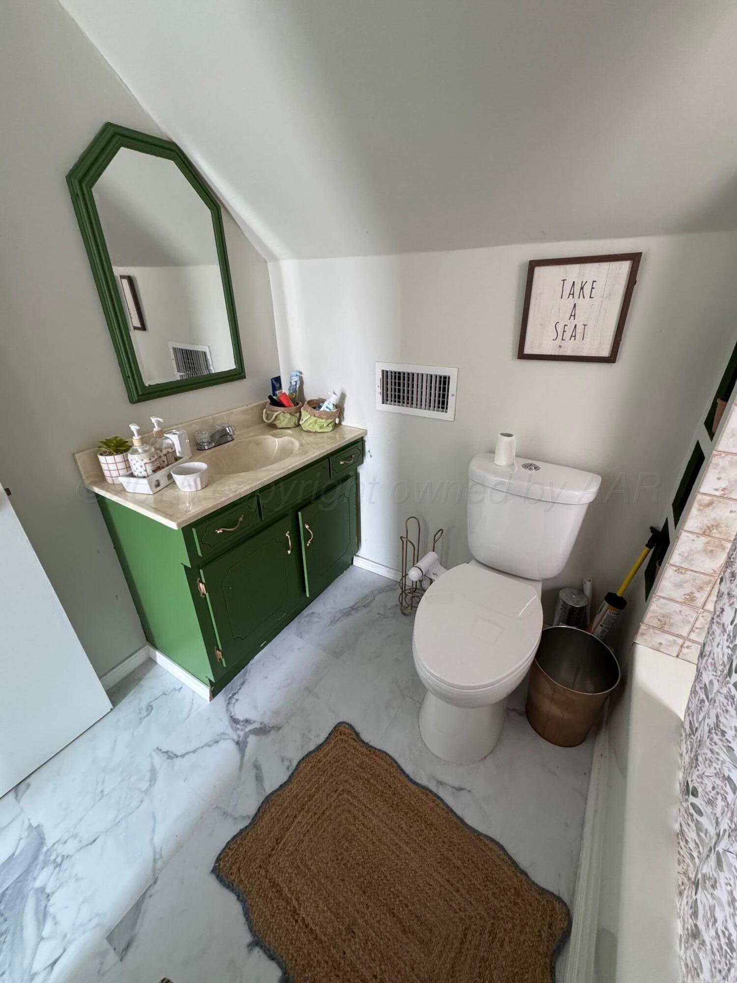 513 South Eton Street Perryton, TX 79070 - Photo 71 of 72 a bathroom with a toilet sink vanity mirror and mirror