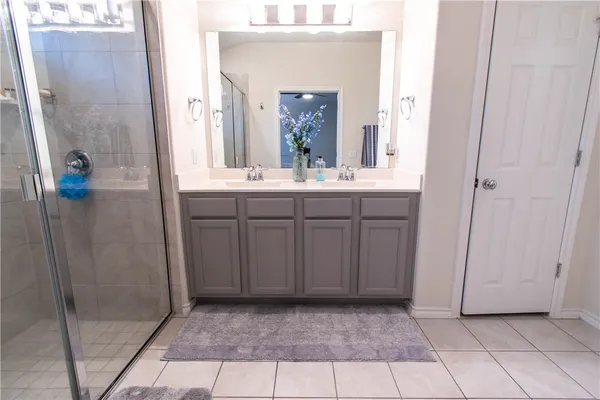 a bathroom with a glass shower door and a sink