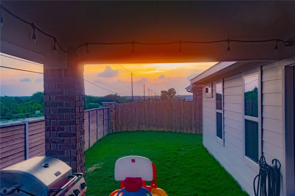a view of a yard with wooden fence