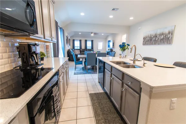 a kitchen with stainless steel appliances granite countertop a sink a stove and cabinets