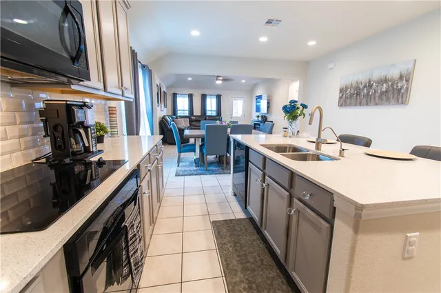 a kitchen with stainless steel appliances granite countertop a sink a stove and cabinets