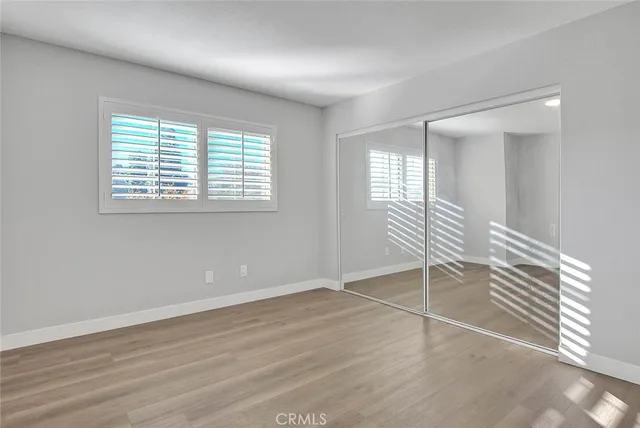 a view of a hallway with wooden floor and a bathroom
