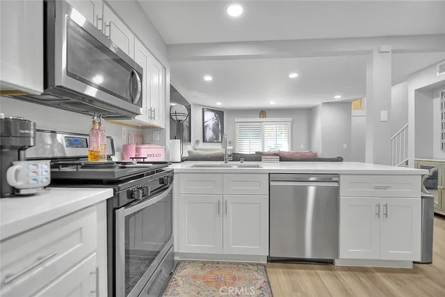 a kitchen with stainless steel appliances granite countertop a stove a sink and a microwave