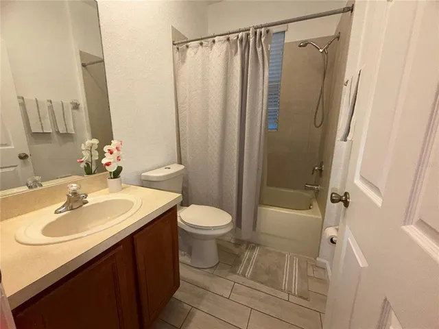 a bathroom with a sink a toilet a mirror and shower