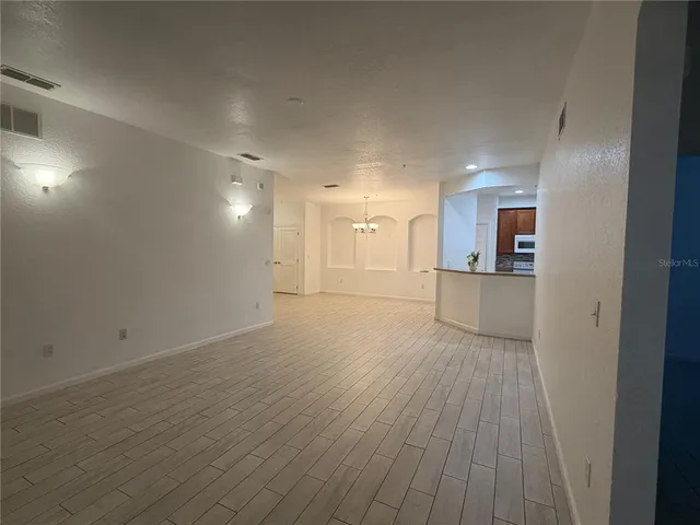 a view of a room with wooden floor and a kitchen