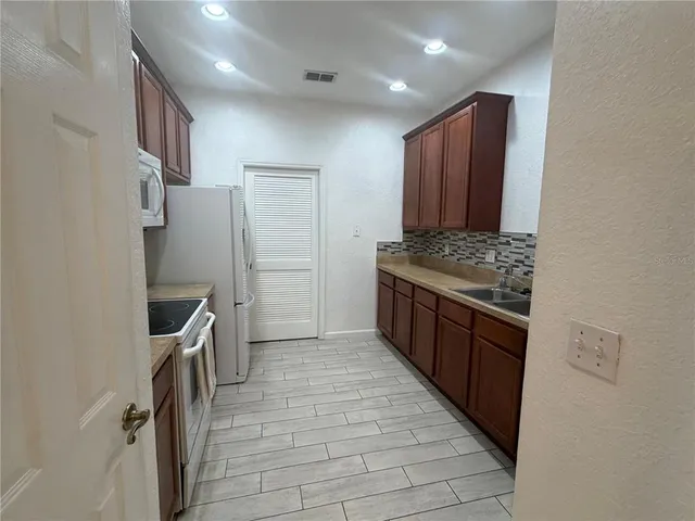 a kitchen with stainless steel appliances granite countertop a refrigerator and a stove
