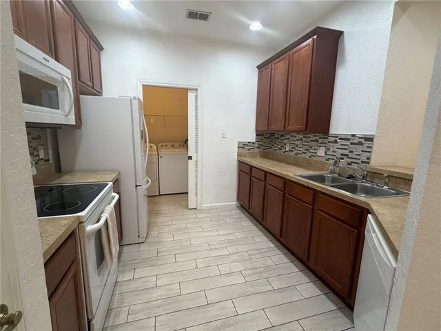 a kitchen with stainless steel appliances granite countertop a stove a sink and a refrigerator