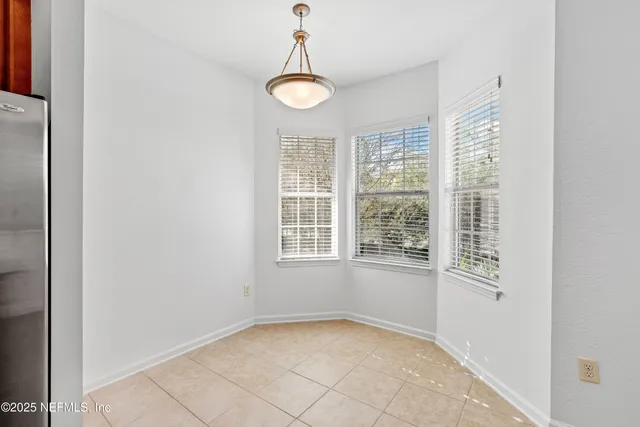 a bedroom with a bed a dresser and next to a window
