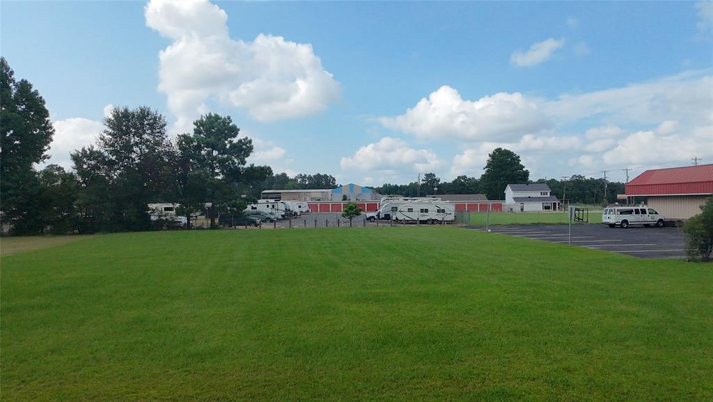 a view of an house with a big yard and a large tree