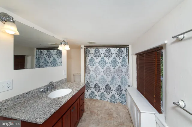 a bathroom with a granite countertop sink and a mirror
