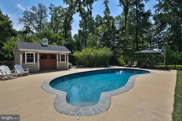 a view of a house with swimming pool and sitting area