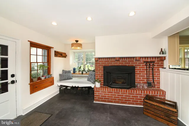 a living room with furniture a fireplace and a floor to ceiling window