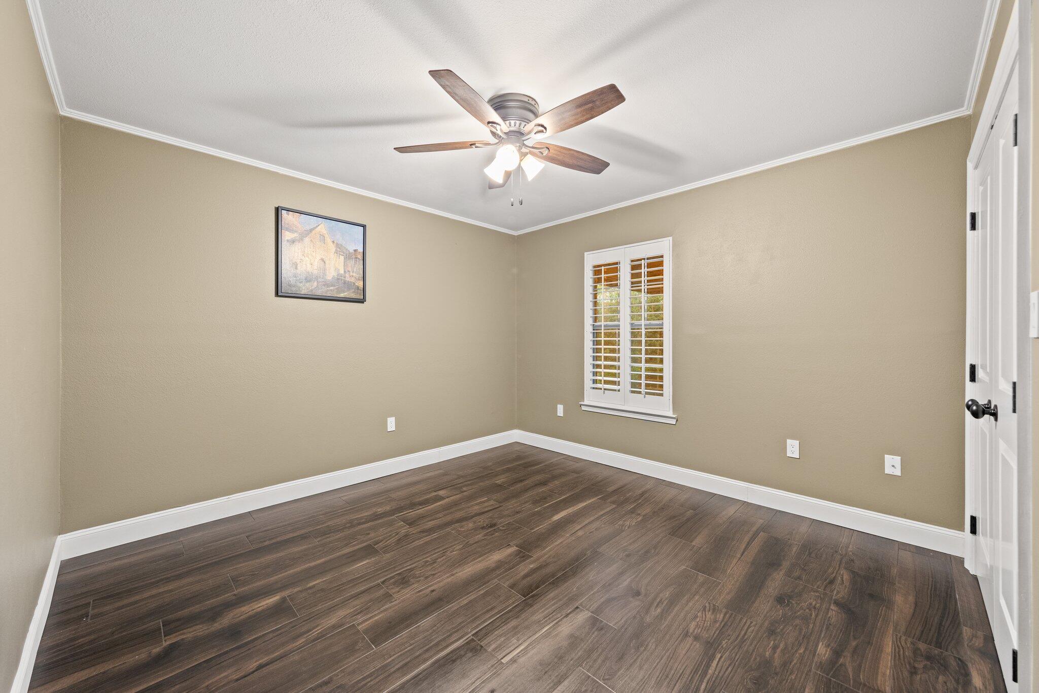 1825 Huntington Road Niceville, FL 32578 - Photo 39 of 68 a view of an empty room with wooden floor and a ceiling fan