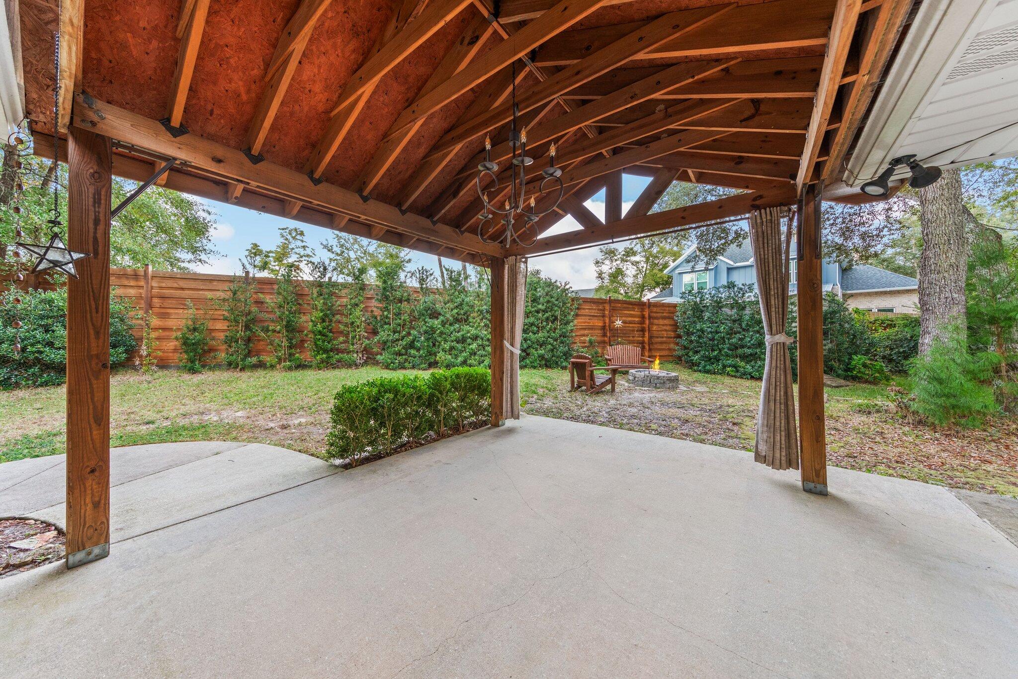 1825 Huntington Road Niceville, FL 32578 - Photo 48 of 68 a view of a backyard with floor to ceiling windows and wooden roof