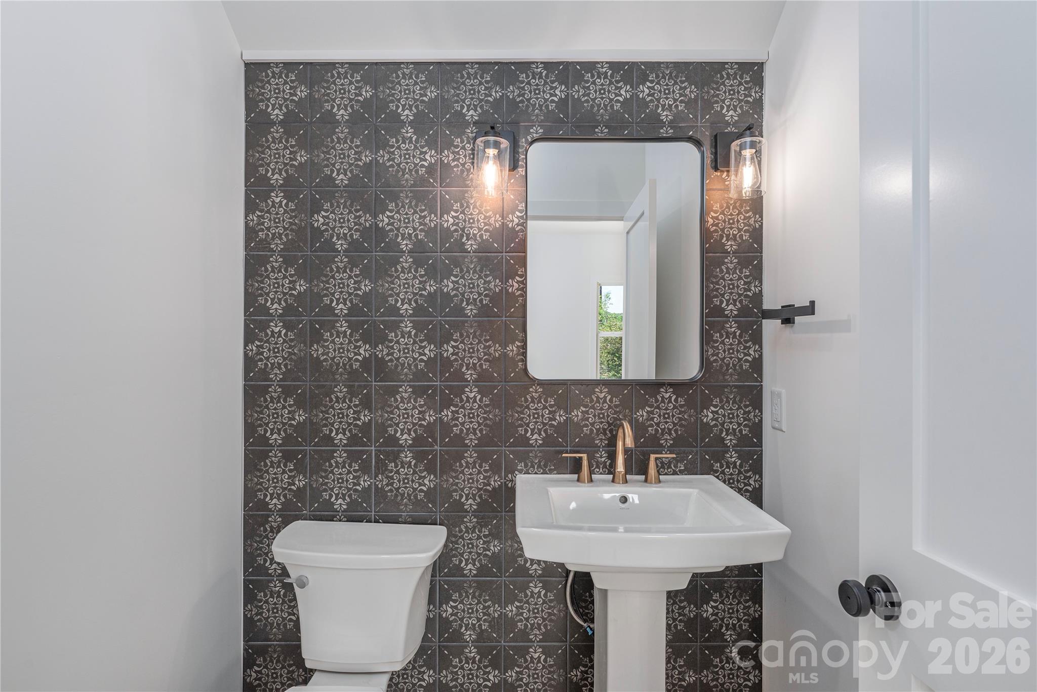 32 Oak Hill Road Candler, NC 28715 - Photo 14 of 29 a bathroom with a toilet sink and mirror