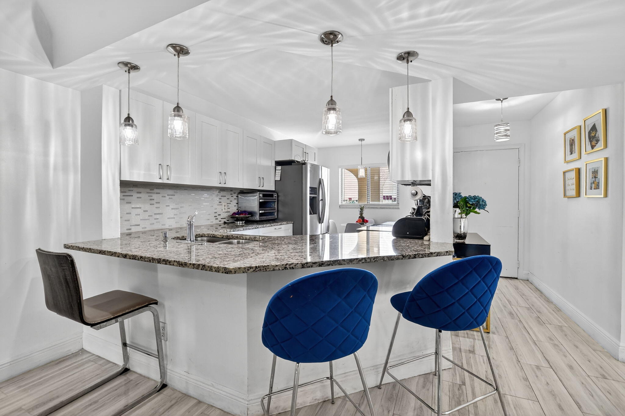 a kitchen with stainless steel appliances granite countertop a sink a stove a dining table and chairs with wooden floor