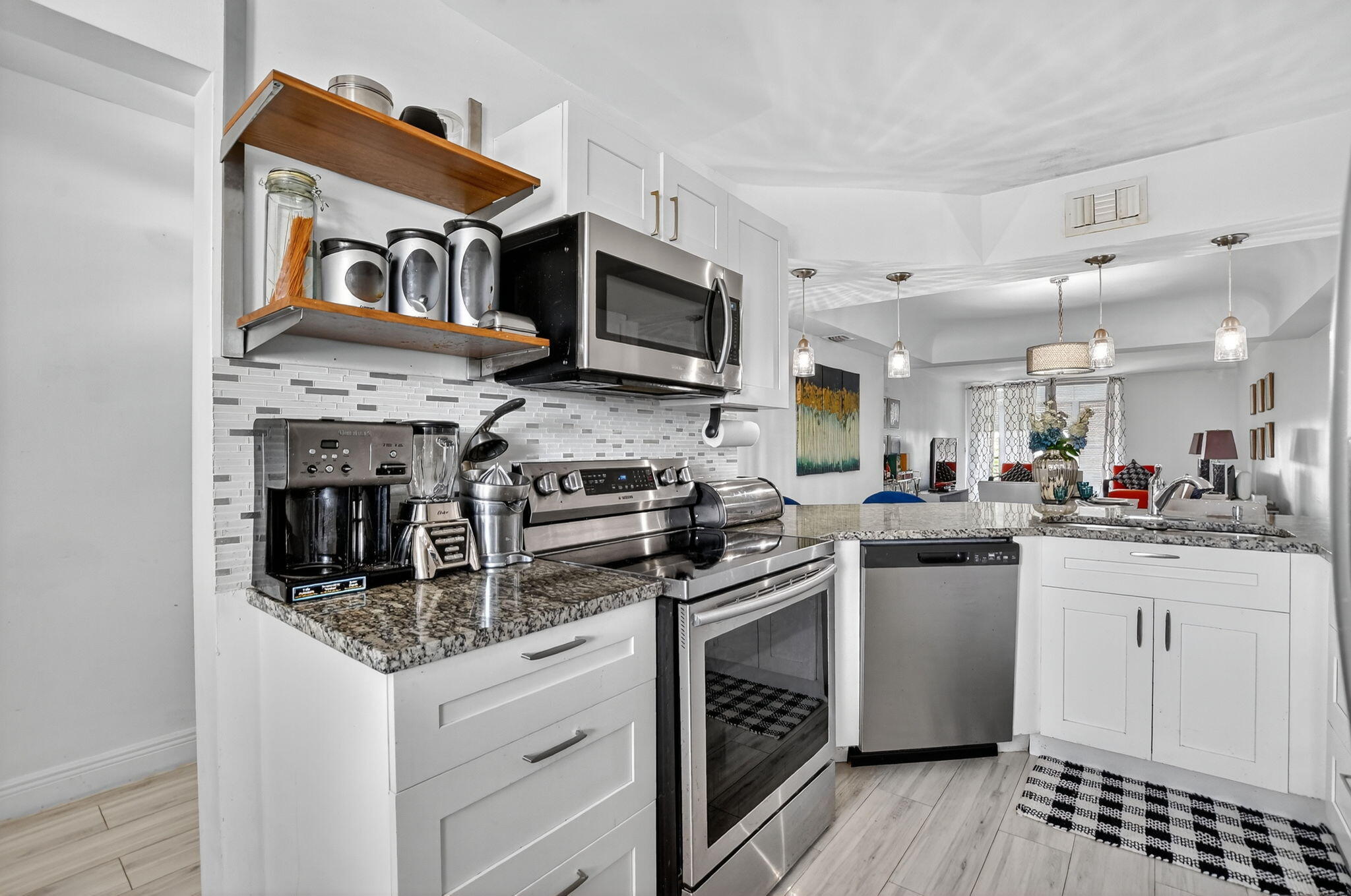 23277 Barwood Lane North, Unit 403 Boca Raton, FL 33428 - Photo 4 of 30 a kitchen with stainless steel appliances granite countertop a stove top oven a sink dishwasher and white cabinets