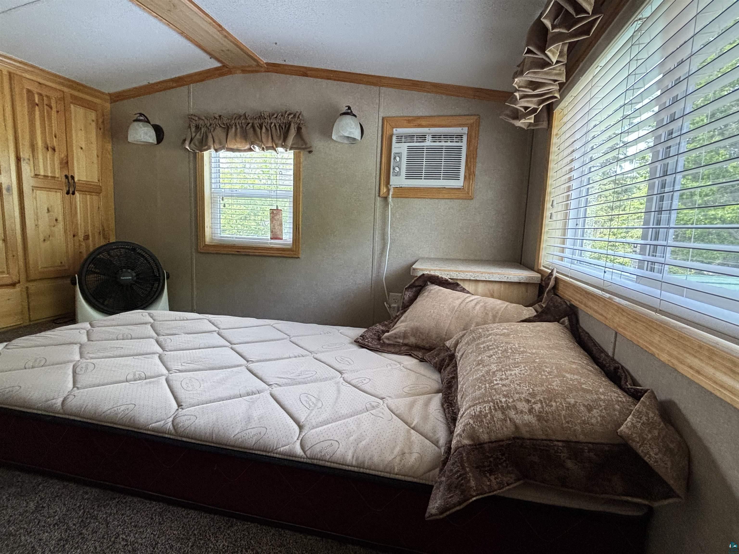 9442 Bear Ridge Drive Orr, MN 55771 - Photo 15 of 26 Bedroom with lofted ceiling, an AC wall unit, and crown molding