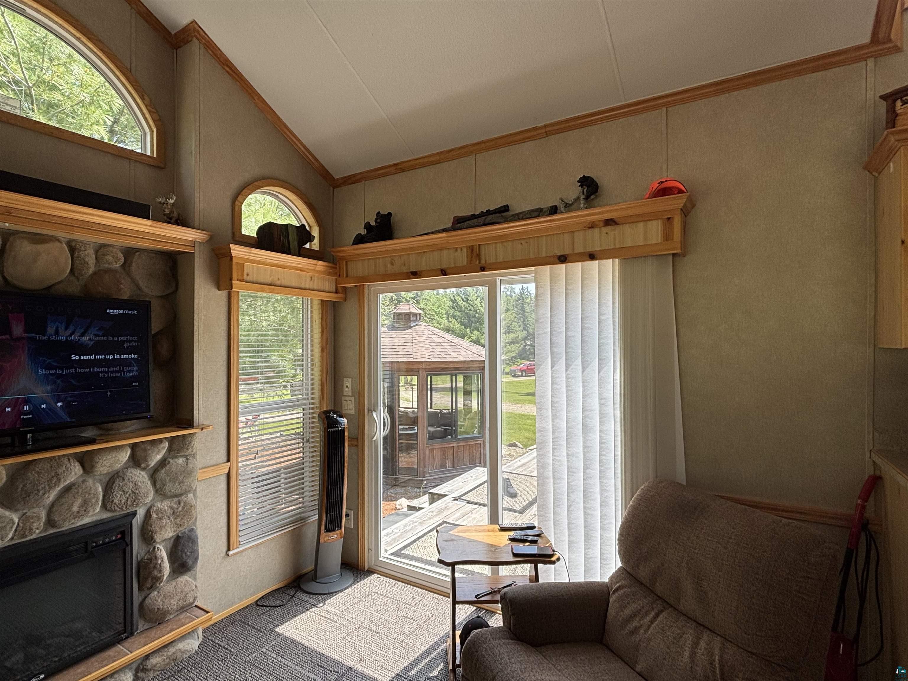 9442 Bear Ridge Drive Orr, MN 55771 - Photo 5 of 26 Doorway with crown molding, vaulted ceiling, a stone fireplace, and healthy amount of natural light