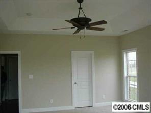 3104 East Lawyers Road Monroe, NC 28110 - Photo 7 of 7 a view of a hallway with a chandelier fan and wooden floor
