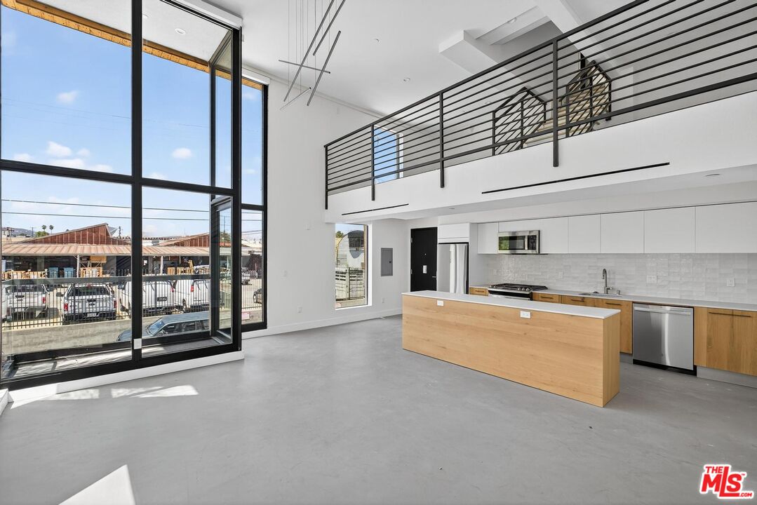 a large kitchen with stainless steel appliances granite countertop a stove and a refrigerator