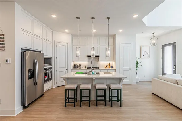 a kitchen with white cabinets and appliances