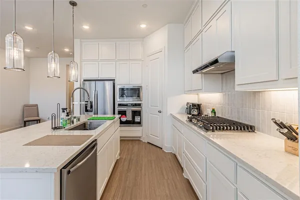 a kitchen with stainless steel appliances a sink stove and cabinets