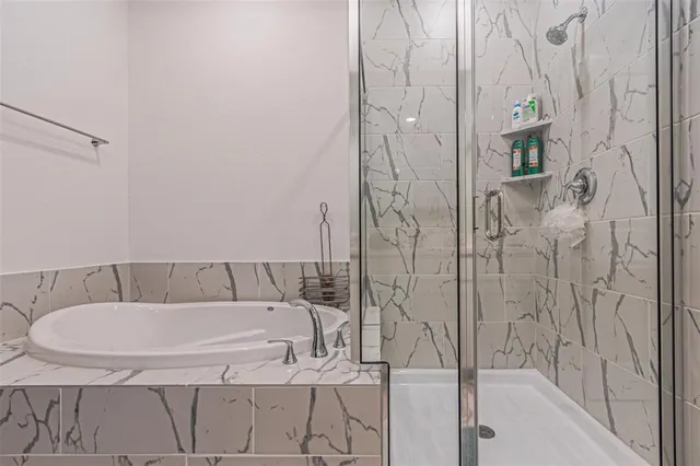 a bathroom with a double vanity sink a mirror a bathtub and shower