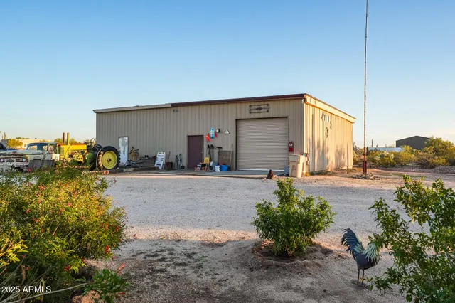 a backyard of a house with table and chairs under an umbrella