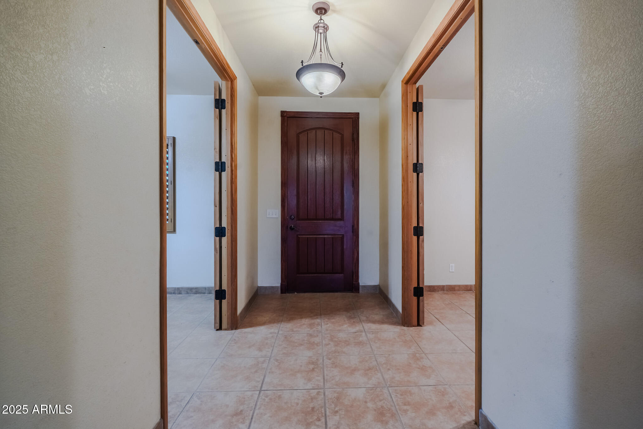 11003 North Hohokam Road Florence, AZ 85132 - Photo 8 of 90 a view of a hallway with wooden floor and a chandelier