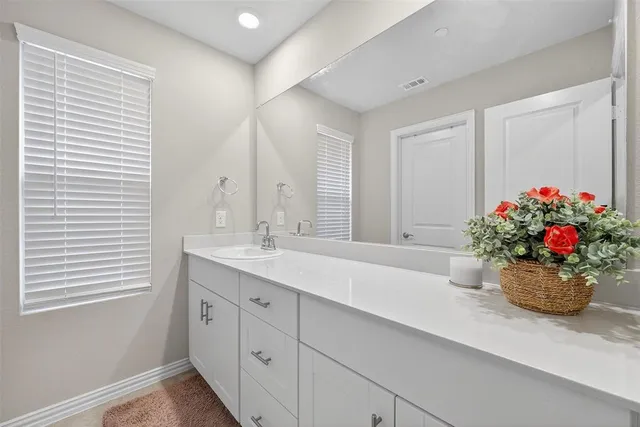 a bathroom with a sink a large mirror and a window