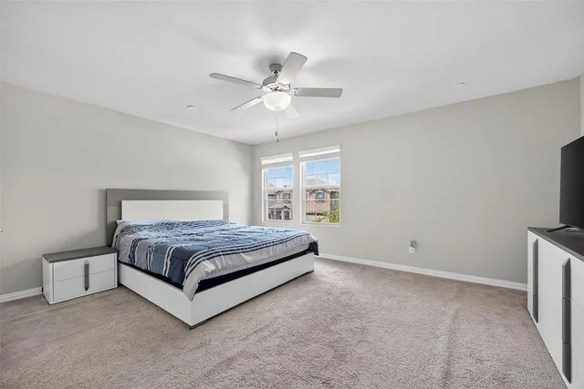 a spacious bedroom with a bed and a flat screen tv