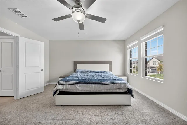 a spacious bedroom with a bed and a chandelier