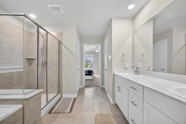 a spacious bathroom with a double vanity sink toilet and shower