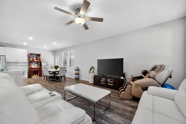 a living room with kitchen island and a wooden floor