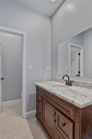 a bathroom with a granite countertop sink and a mirror