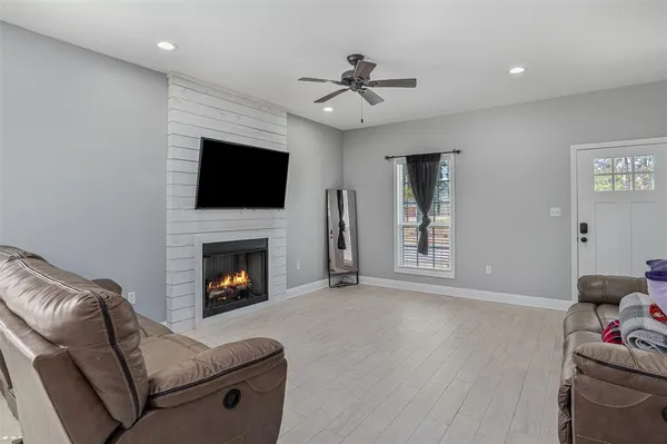 a living room with furniture a flat screen tv and a fireplace